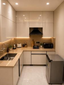 a kitchen with white cabinets and a counter top at Lime Tree Hotel Golf Course Road, Gurgaon in Gurgaon +7 photos