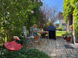 a woman sitting at a table in a garden at Ferienhaus Klöber in Lichtenhain +4 photos