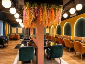 a restaurant with tables and chairs and flowers hanging from the ceiling at Ravira Resort in Sītāpur