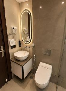 a bathroom with a toilet and a sink and a mirror at Lime Tree Hotel Golf Course Road, Gurgaon in Gurgaon