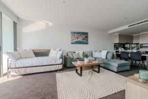 a living room with a couch and a table at On Flinders Wollongong in Wollongong