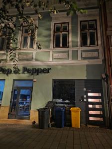 ein Laden mit zwei Mülltonnen vor einem Gebäude in der Unterkunft Reset Apartment in Cluj-Napoca