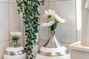 two silver and white vases with white flowers in them at Landleben 2 in Erkelenz