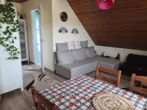 a living room with a couch and a table at Tahi Apartman in Tahitótfalu