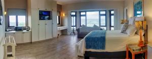 a bedroom with a bed and a balcony with the ocean at The View in Port Alfred