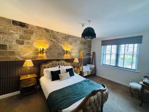 a bedroom with a large bed and a stone wall at Sneaton Castle in Whitby