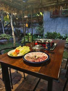 a wooden table with a plate of food on it at สวนฉัน Igarden in Ban Pang Champi +72 photos
