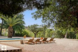 a group of lounge chairs and a swimming pool at Villa Fantaxat by Abahana Villas in Benissa