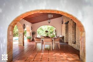 a dining room with an archway and a table and chairs at Villa Fantaxat by Abahana Villas in Benissa
