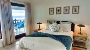 a bedroom with a bed with a view of the ocean at The View in Port Alfred
