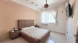 a bedroom with a large bed and a window at marhaba apartement in Oujda