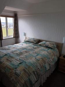 a bedroom with a bed with a quilt on it at Sefton Lodge SEAFRONT ,PANORAMIC SEA VIEW ENSUITE BALCONY ROOMS AVAILABLE, GUEST GARDEN in Paignton