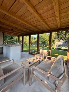 a patio with couches and a table with a table at Skyframe Cabin in Pucheni