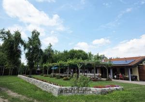 a garden in front of a building with a stone wall at Botte dei Benandanti in Vivaro