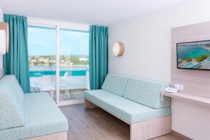 a living room with a couch and a window at HSM Sandalo Beach in Magaluf