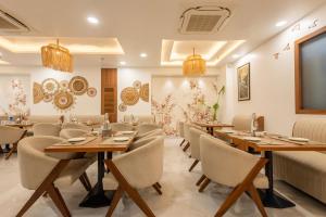 a dining room with wooden tables and chairs at Treebo Premium The Maulshri, Behind Health Vistaar City in Lucknow