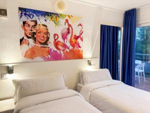two beds in a room with a painting on the wall at Hotel Las Vegas in Calella