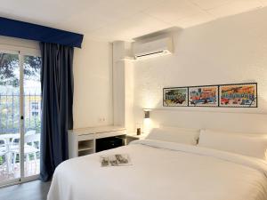 a bedroom with a white bed and a window at Hotel Las Vegas in Calella