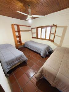 a bedroom with two beds and a ceiling at Atardecer Cabaña frente al rio in Ituzaingó