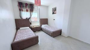 a room with two beds and a couch in it at marhaba apartement in Oujda +3 photos