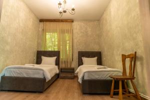 a bedroom with two beds and a window at Maestro Rest House Dilijan in Dilijan