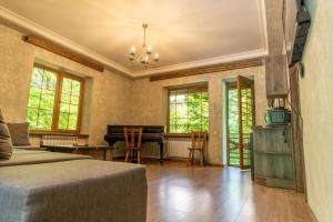 a bedroom with a bed and a piano in a room at Maestro Rest House Dilijan in Dilijan