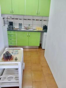 a kitchen with green cabinets and a white table at Villa creole in Le Diamant +8 photos