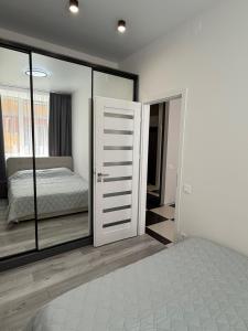 a bedroom with a bed and sliding glass doors at Морской Двор in Chornomorsk