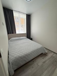 a bedroom with a bed and a window at Морской Двор in Chornomorsk