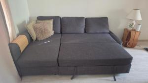 a gray couch with pillows on it in a living room at A&J apartments in Klaipėda