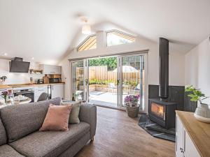 a living room with a couch and a stove at Olchard Lodge in Newton Abbot