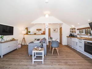 a kitchen and living room with a couch and a table at Olchard Lodge in Newton Abbot
