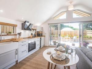 a kitchen and living room with a table at Olchard Lodge in Newton Abbot +22 photos
