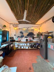 a room with a kitchen with a counter and a refrigerator at Karma Muse Hotel in La Libertad