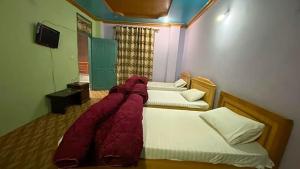 a bedroom with two beds with red blankets at Moon Palace by MZ Hotels Pakistan KPK in Mingāora