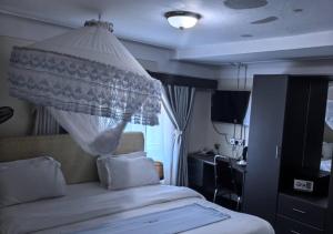 a bedroom with a bed with a mosquito net at Kaa Highway Hotel Mukono in Mukono