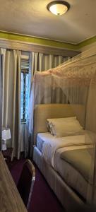 a bedroom with a bed with a canopy at Kaa Highway Hotel Mukono in Mukono