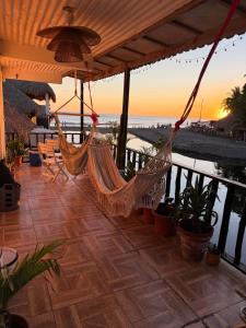 a hammock on a porch with a view of the ocean at Karma Muse Hotel in La Libertad