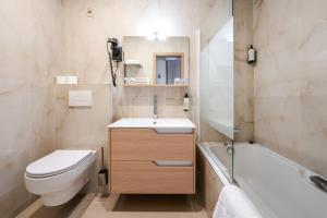 ゲブヴィレールにあるThe Originals City Hotel de l Ange Guebwillerのトイレと洗面台と浴槽のある浴室 +18枚の写真