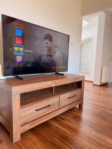 a flat screen tv sitting on top of a wooden entertainment center at Priestranný apartmán s veľkorysým výhľadom in Rača