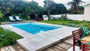 a swimming pool in a backyard with two chairs and a table at The View in Port Alfred +30 photos