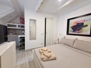 a white bedroom with a bed and a kitchen at Lake Suite in Trevignano Romano