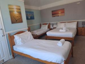 a room with three beds in a room at A Maiden Rest in Weymouth