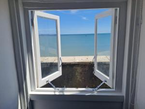 an open window with a view of the ocean at A Maiden Rest in Weymouth