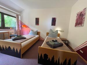 two beds in a room with trees painted on the walls at Waldgarten Marienau in Höchenschwand