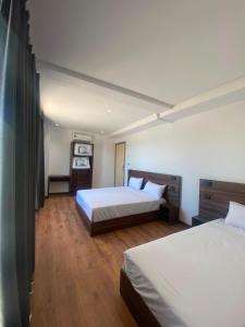 a bedroom with two beds and wooden floors at Nezha Hotel in Tangier
