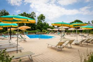a pool with chairs and umbrellas at Botte dei Benandanti in Vivaro