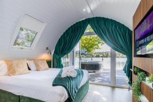 a bedroom with a large bed and a large window at AvantGlamp in Marston Green