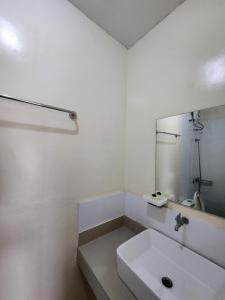 a white bathroom with a sink and a mirror at R Hotel Centro and Restaurant in Marinduque