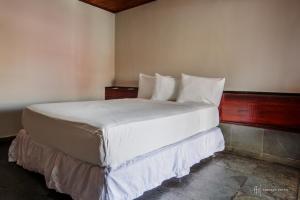 a bedroom with a bed with white sheets and pillows at Rede Andrade Galeão in Porto Seguro +22 photos